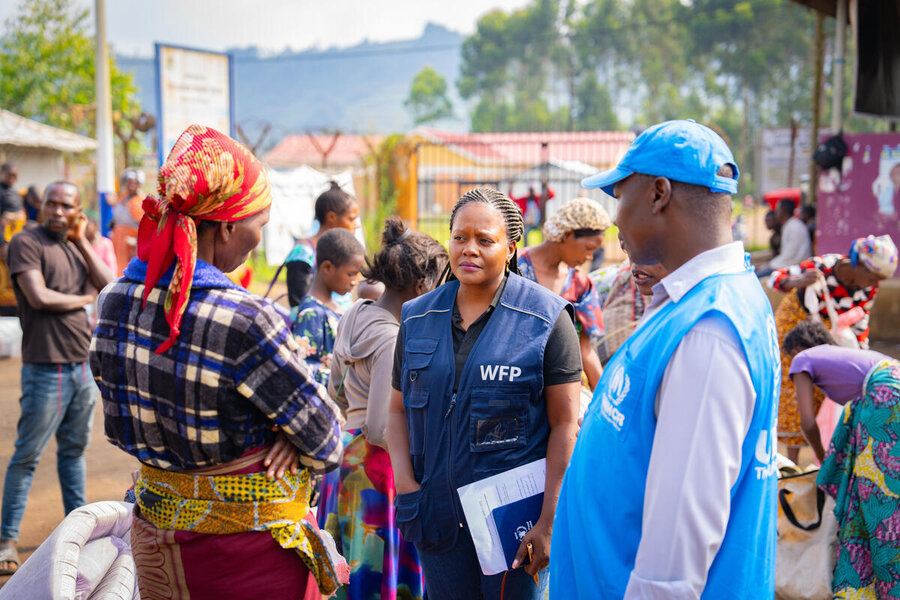 A female WFP operative and a UN colleague talk to a woman at transit centre for DRC refugees in Uganda