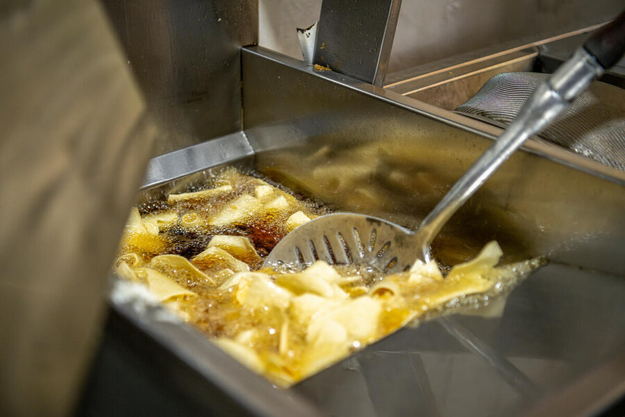 Potato chips cooking in a professional fryer