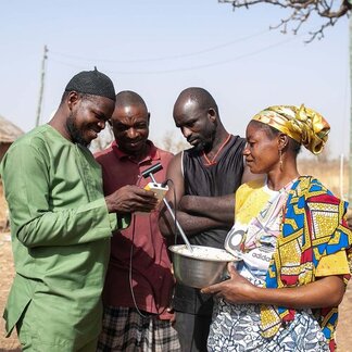 Small-holder Farmers in Tamale checking the moisture content of grains using a moisture meter