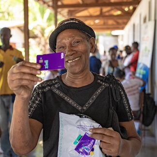 Man holding up a card for electronic cash transfer.