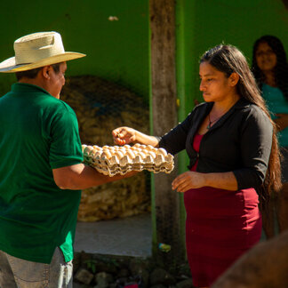 La Quique takes pride in her new livelihood, production, and commercialization of eggs, which has allowed people in her community, such as Gervacio, to improve their diet and income. Photo: WFP/Nick Roeder