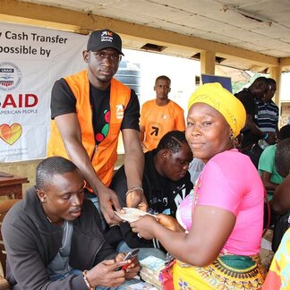 A beneficiary is receiving money via cash distribution programme