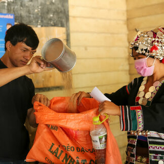 Man and woman filling a bag with nutritious food supplies provided by WFP