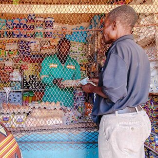 Lusaka district, Zambia. A man buys groceries under the Social Cash Transfer programme. Photo: WFP/Andy Higgins