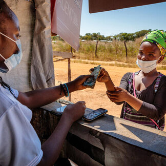 A woman refugee withdraws WFP cash assistance. Photo: WFP/Andy Higgins
