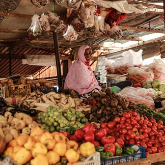 A smiling woman on her market stall