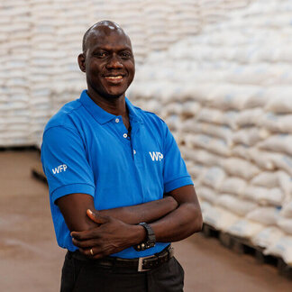 A man wearing a WFP t-shirt in a warehouse