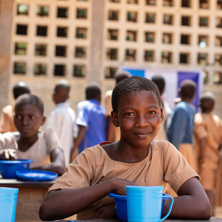 A school child with his meal provided by WFP