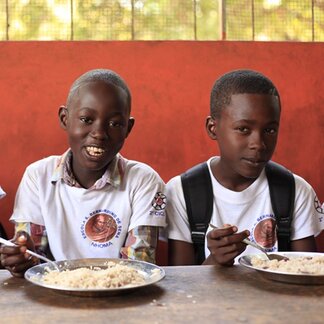Schoolchildren enjoying school meals supported by WFP. Photo:  WFP/Renata Lobo