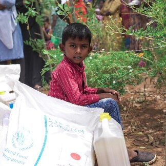 Nesvin sitting by the bags of rice, lentils and oil which his family received through WFP Sri Lanka’s emergency operation in-kind assistance in Vavuniya, North – Sri Lanka. Photo credit: WFP/Carol Taylor