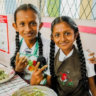 Morning school meals being served to R.K. Harani and her friend, two Grade 5 students of St. John’s Maha Vidyalaya, Colombo 15. Photo credit: WFP/Carol Taylor