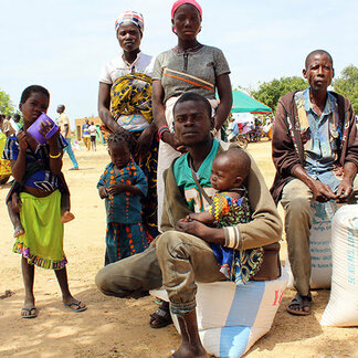 Family with sacks of food items distributed to internally displaced persons in Burkina Faso